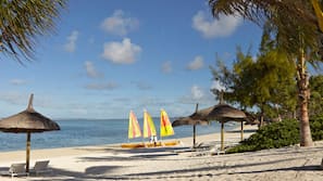 On the beach, white sand, sun-loungers, beach umbrellas
