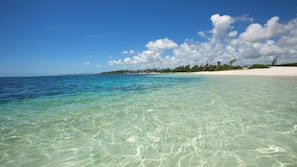 On the beach, white sand, sun-loungers, beach umbrellas