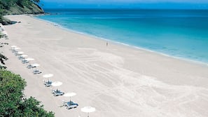 Plage, sable blanc, chaises longues, parasols