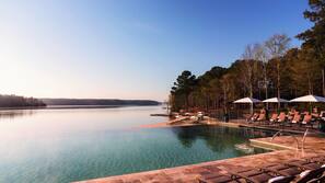Una piscina al aire libre, sombrillas, tumbonas
