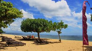 On the beach, white sand, sun-loungers, beach towels