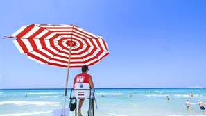 Sulla spiaggia, sabbia bianca, lettini da mare, ombrelloni