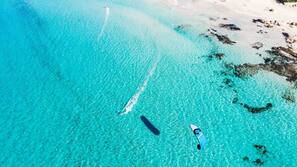 Sulla spiaggia, sabbia bianca, lettini da mare, ombrelloni
