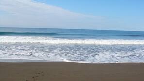 Ubicación a pie de playa, arena negra y surf