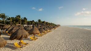 On the beach, white sand, sun loungers, beach umbrellas