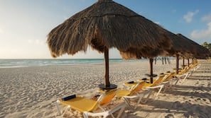 On the beach, white sand, sun loungers, beach umbrellas