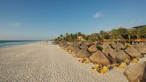 On the beach, white sand, sun loungers, beach umbrellas