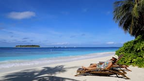 Plage, sable blanc, chaises longues, parasols
