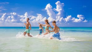 Am Strand, weißer Sandstrand, Liegestühle, Sonnenschirme