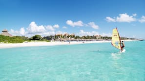 Am Strand, weißer Sandstrand, Liegestühle, Sonnenschirme