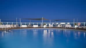 Una piscina al aire libre, tumbonas