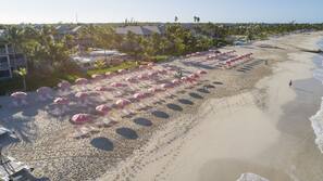 On the beach, white sand, sun loungers, beach umbrellas