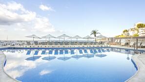Una piscina al aire libre, tumbonas