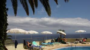 Piscine couverte, piscine extérieure, parasols de plage, chaises longues