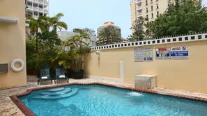 Una piscina al aire libre, tumbonas