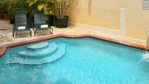 Una piscina al aire libre, tumbonas