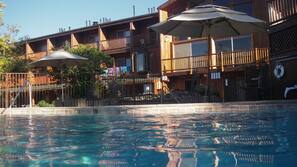 Una piscina al aire libre, sombrillas