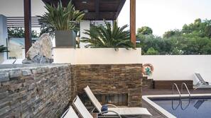 Una piscina al aire libre, tumbonas
