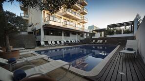 Una piscina al aire libre, tumbonas