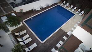 Una piscina al aire libre, tumbonas