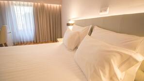 Minibar, escritorio, cortinas opacas y tabla de planchar con plancha