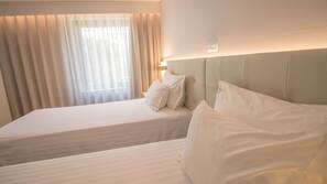 Minibar, escritorio, cortinas opacas y tabla de planchar con plancha