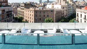 Una piscina al aire libre, tumbonas