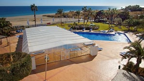 Una piscina cubierta, una piscina al aire libre, tumbonas