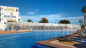 Una piscina cubierta, una piscina al aire libre, tumbonas