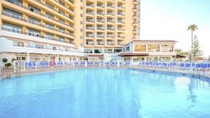 Una piscina cubierta, una piscina al aire libre, sombrillas, tumbonas