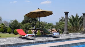 Una piscina al aire libre, tumbonas