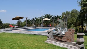 Una piscina al aire libre, tumbonas