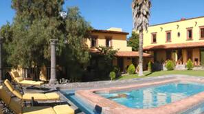 Una piscina al aire libre, tumbonas