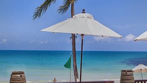 Am Strand, weißer Sandstrand, Liegestühle, Sonnenschirme