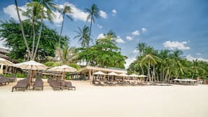 Am Strand, weißer Sandstrand, Liegestühle, Sonnenschirme