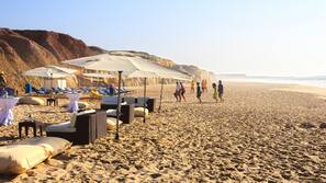 On the beach, white sand, sun loungers, beach umbrellas