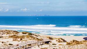 On the beach, white sand, sun loungers, beach umbrellas