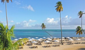 On the beach, white sand, sun loungers, beach umbrellas