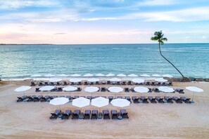 On the beach, white sand, sun loungers, beach umbrellas