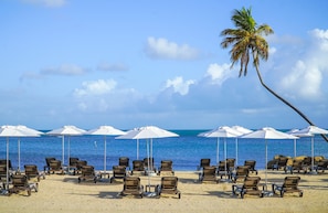 On the beach, white sand, sun loungers, beach umbrellas