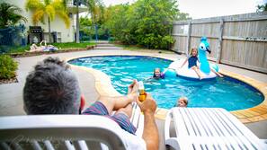 Una piscina al aire libre, tumbonas