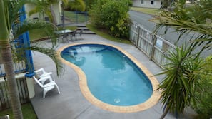 Una piscina al aire libre, tumbonas
