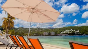 On the beach, white sand, sun loungers, beach umbrellas