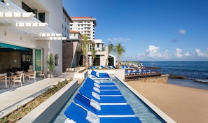 On the beach, white sand, beach cabanas, sun loungers
