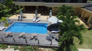 Una piscina al aire libre, sombrillas, tumbonas