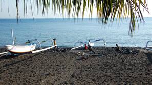 Am Strand, schwarzer Sandstrand, Strandtücher, Sporttauchen