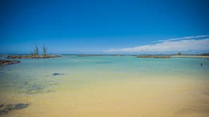 On the beach, white sand, sun-loungers, beach umbrellas