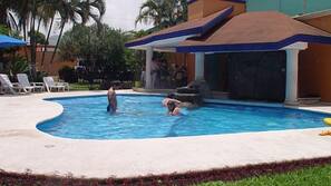 Una piscina al aire libre, sombrillas, tumbonas