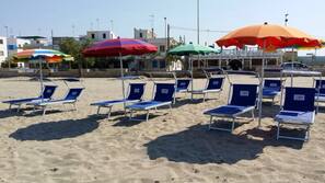 Plage, chaises longues, parasols
