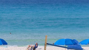 On the beach, white sand, sun loungers, beach umbrellas